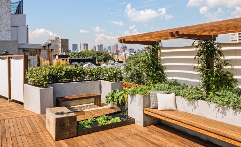 A luxurious and sustainable NYC rooftop terrace with high-performance decking, integrated planters, and skyline views.